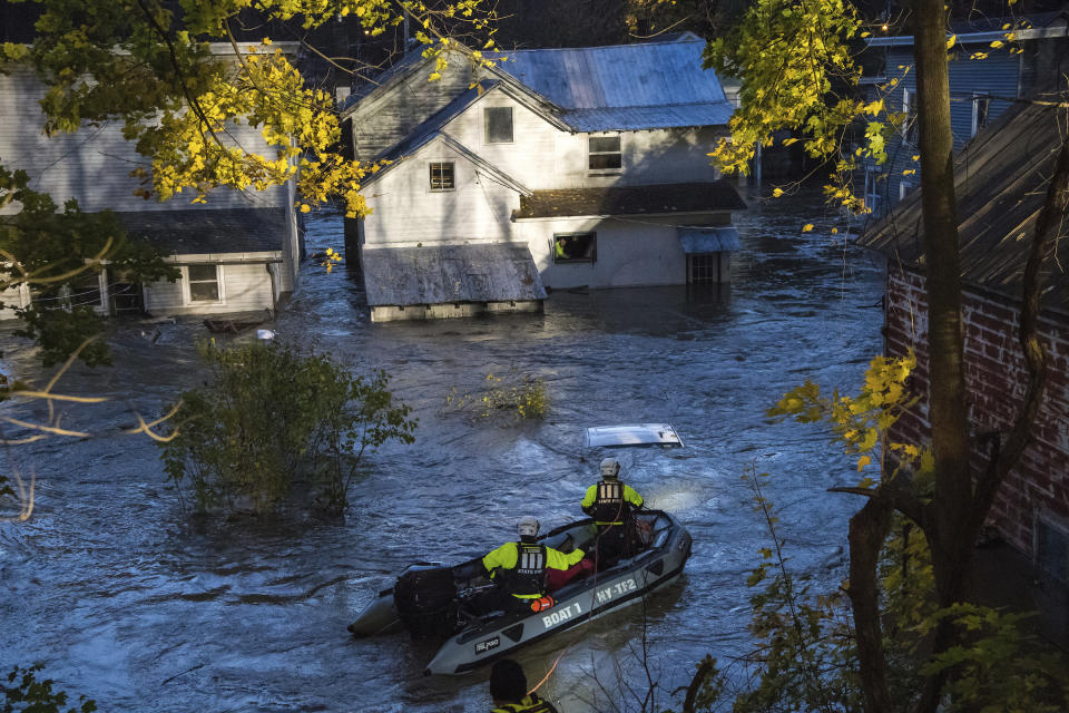 In this photo provided by the New York State Governor's Office, a man looks from a window of a house being flooded by rising waters of the East Canada Creek as police arrive in a rescue boat, Friday, Nov. 1, 2019 in Dolgeville, N.Y. Several hundred people were being evacuated in scattered areas around the state because of high waters. (Darren McGee/New York State Governor's Office via AP)