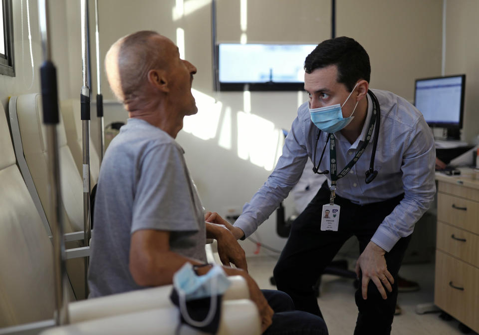 Image: Vinicius Molla, a hematologist and volunteer of the clinical trial of Oxford COVID-19 vaccine, examines a patient at a consulting room in Sao Paulo, Brazil (Amanda Perobelli / Reuters)