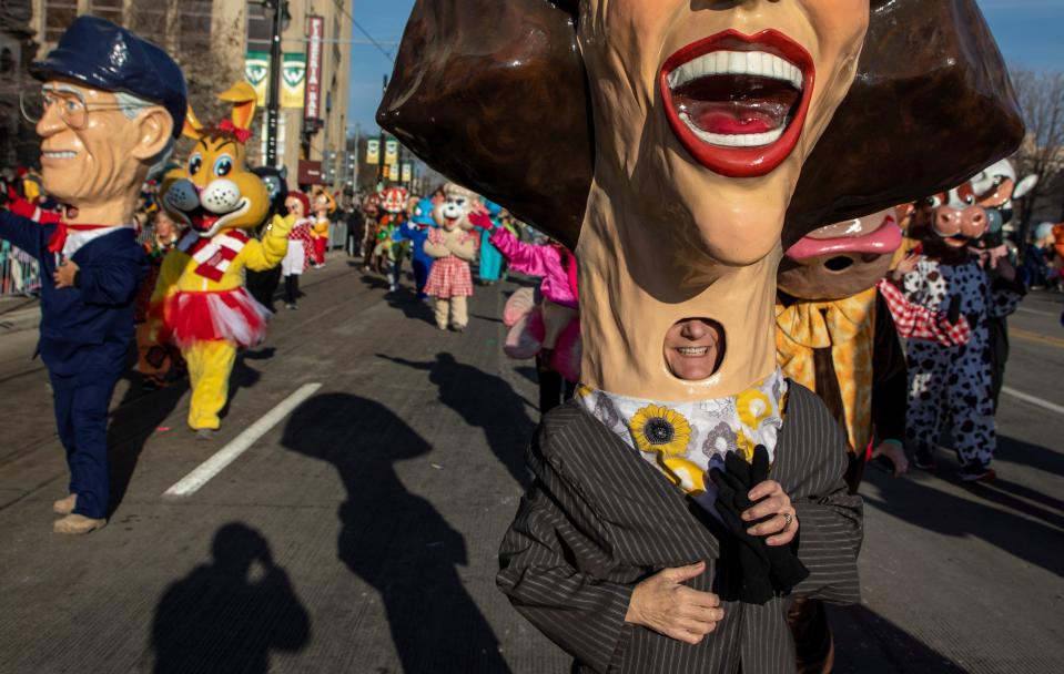 A person wearing a big head costume smiles during the 96th America's Thanksgiving Parade Presented by Gardner White in Detroit on Thursday, Nov. 24, 2022.