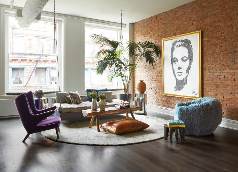 In the living room, a portrait of Grace Kelly by John Codling becomes the focal point of a multifaceted seating area highlighted by a Papa Bear chair by Hans Wegner in Place Textiles mohair, a Huniford Design Studio chair covered in curly Tibetan lambswool by Dualoy, and a repurposed African stool and leather floor pillow.