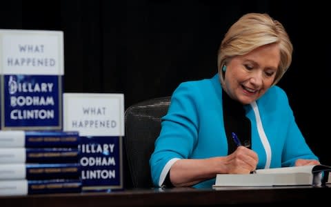 Hillary Clinton signs a copy of her new book in New York  - Credit: ANDREW KELLY/ REUTERS