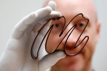 Gaetan Richard poses with the logo of the Miam Factory 3D printing chocolate company after being printed by a specialized 3D machine in Gembloux, Belgium, April 10, 2017. REUTERS/Francois Lenoir