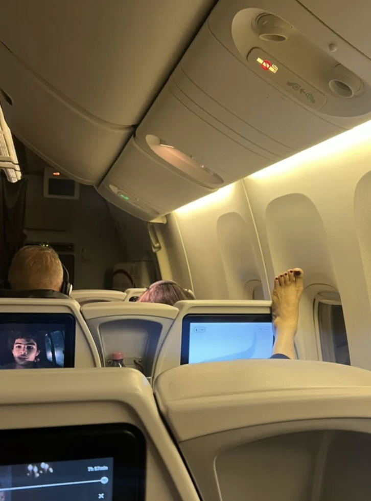 person's bare foot on the plane seat