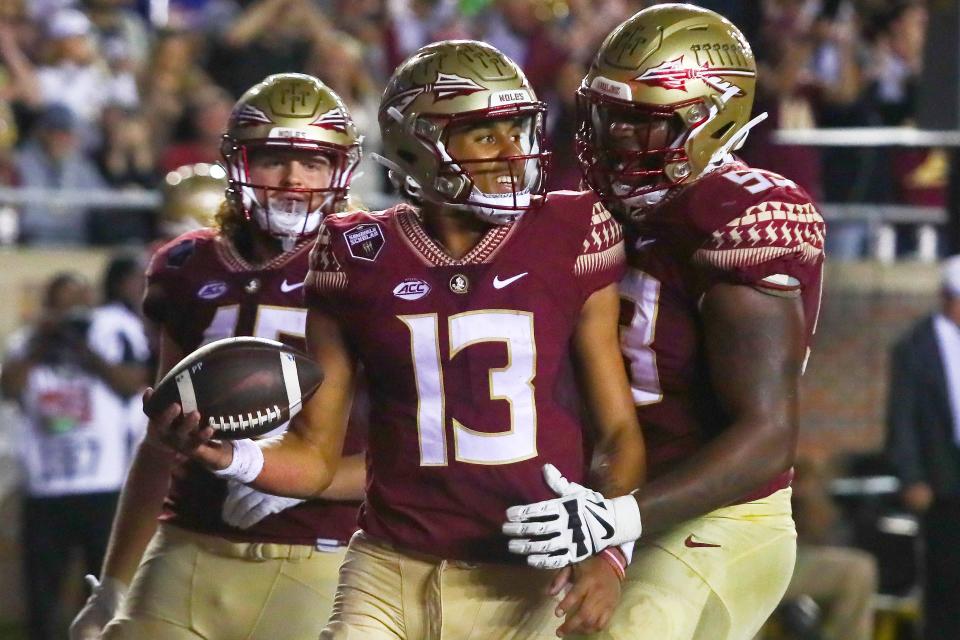 Florida State quarterback Jordan Travis (13) is congratulated by offensive lineman Maurice Smith (53) after scoring a touchdown in the second quarter against Florida on Nov. 25 in Tallahassee, Fla.