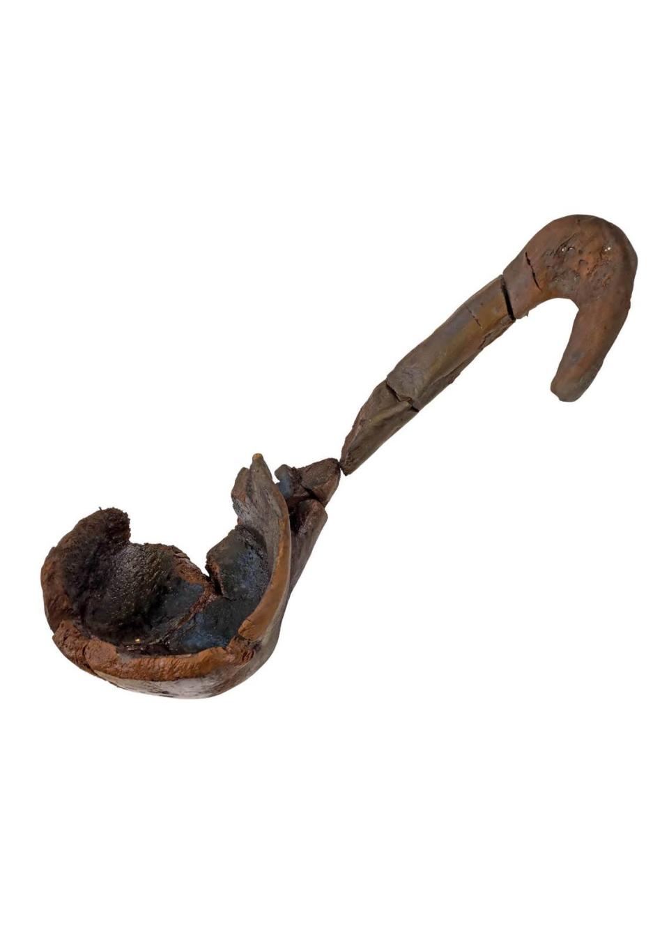 A partially-intact wooden scoop found in the well.