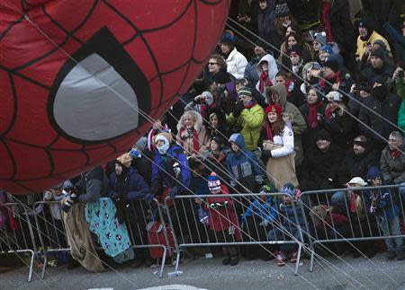 People look on as the Spiderman balloon float makes its way down 6th Avenue during the 87th Macy's Thanksgiving Day parade in New York November 28, 2013. REUTERS/Carlo Allegri