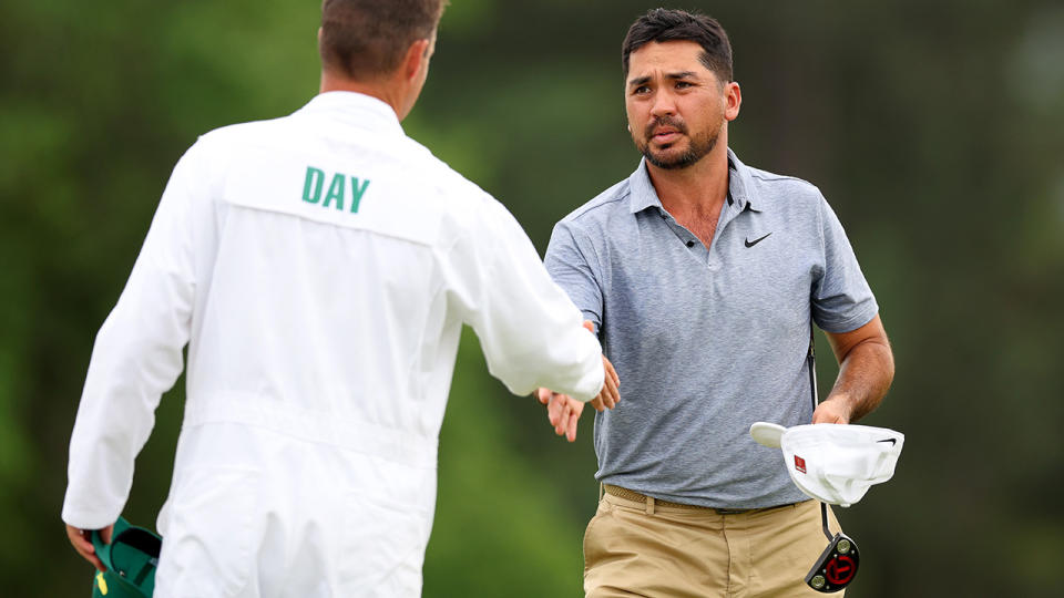 Jason Day shakes hands with his caddie.