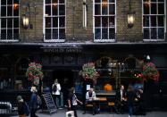 People sit in front of a pub in London Bridge, amid the outbreak of the coronavirus disease (COVID-19) in London