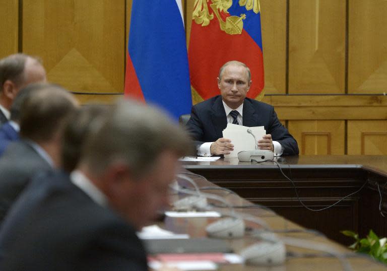 Russian President Vladimir Putin holds a briefing session with permanent members of the Security Council of Russia at the Black Sea Fleet headquarters in Sevastopol on August 13, 2014