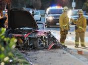 First responders gather evidence near the wreckage of a Porsche sports car that crashed into a light pole on Hercules Street near Kelly Johnson Parkway in Valencia on Saturday, Nov. 30, 2013. A publicist for actor Paul Walker says the star of the "Fast & Furious" movie series has died in a car crash north of Los Angeles. He was 40. Ame Van Iden says Walker died Saturday afternoon. No further details were released. (AP Photo/The Santa Clarita Valley Signal, Dan Watson)