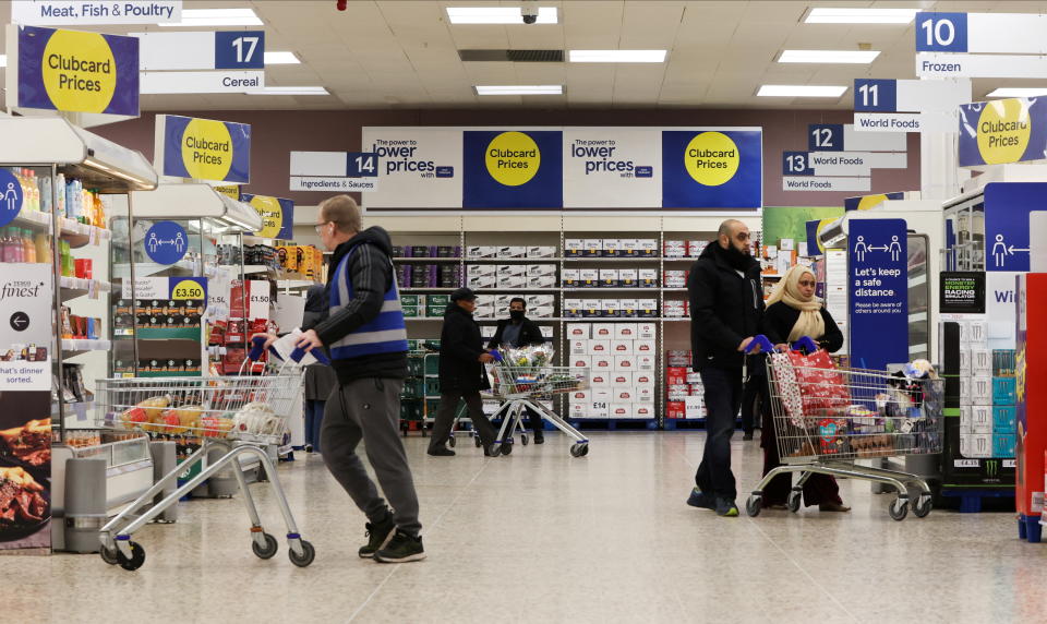 Tesco Shoppers walk next to the clubcard price branding inside a branch of a Tesco Extra Supermarket in London, Britain, February 10, 2022. Picture taken February 10, 2022. REUTERS/Paul Childs