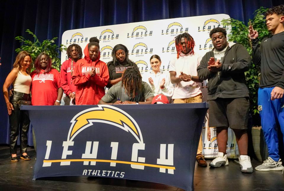 Richard Young signs to the University of Alabama while his family watches at Lehigh Senior High School in Lehigh Acres on Wednesday, Dec. 21, 2022. 