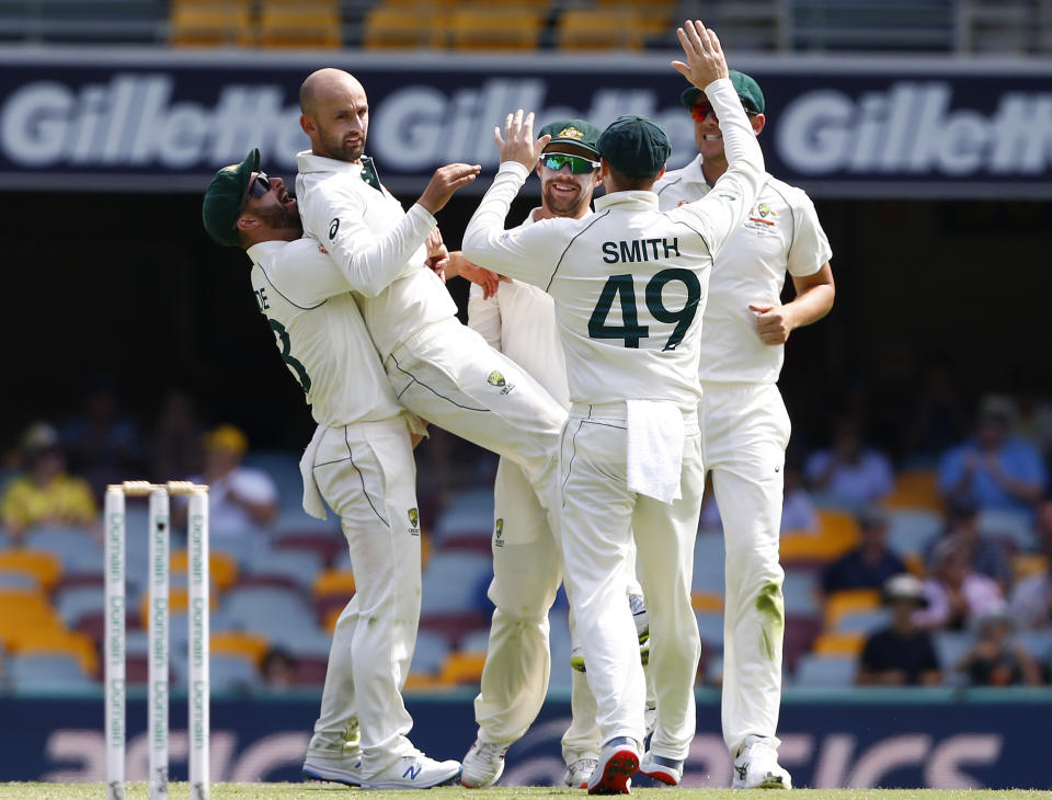 Australia's Nathan Lyon, second from left, celebrates with his teammates after he got the wicket of Pakistan's Babar Azam during their cricket test match in Brisbane, Australia, Sunday, Nov. 24, 2019. (AP Photo/Tertius Pickard)