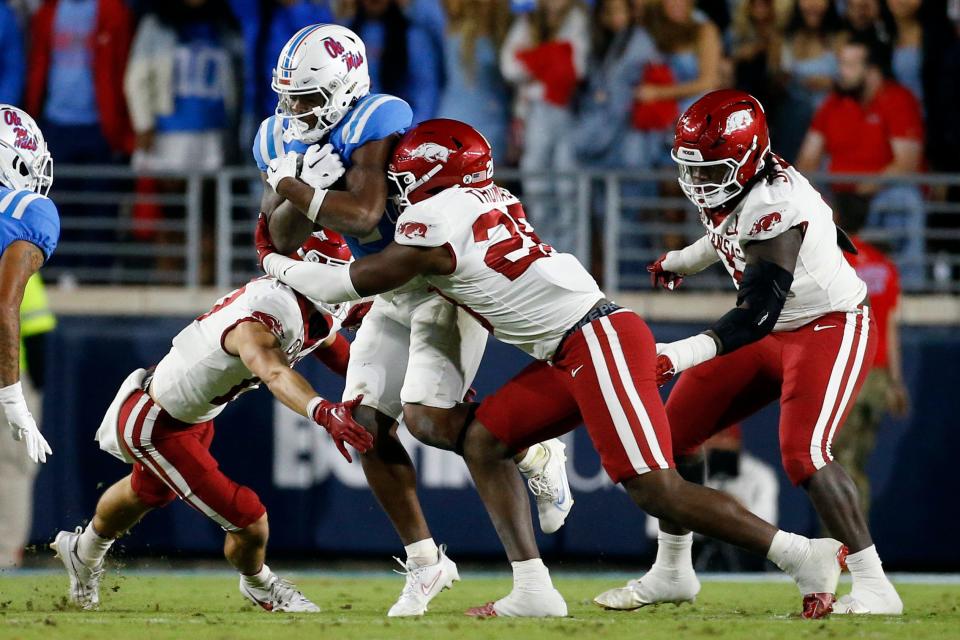 Oct 7, 2023; Oxford, Mississippi, USA; Mississippi Rebels running back Quinshon Judkins (4) runs with the ball as Arkansas Razorbacks defensive back Hudson Clark (17) and linebacker Jaheim Thomas (28) make the tackle during the first half at Vaught-Hemingway Stadium. Mandatory Credit: Petre Thomas-USA TODAY Sports