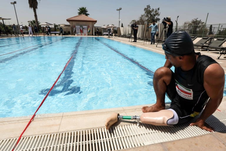 An Iraqi man who lost a limb during the war against the Islamic State group sits by a swimming pool in Arbil, the capital of Iraqi Kurdistan, on September 1, 2018