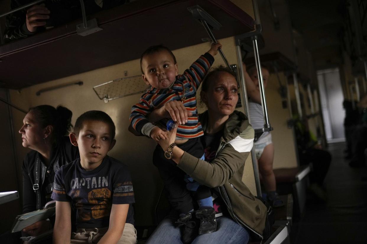 Yana Skakova and her son Yehor who fled from Lysychansk with other people sit in an evacuation train at the train station in Pokrovsk, Ukraine, (AP Photo/Francisco Seco)