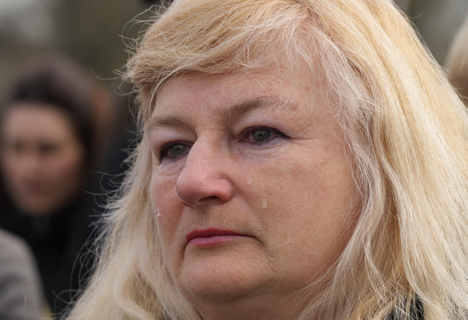 A woman cries during the singing of the national anthem during a visit by Ukrainian President Volodymyr Zelenskyy in Okhtyrka in the Sumy region of Ukraine, Tuesday March 28, 2023. (AP Photo/Efrem Lukatsky)