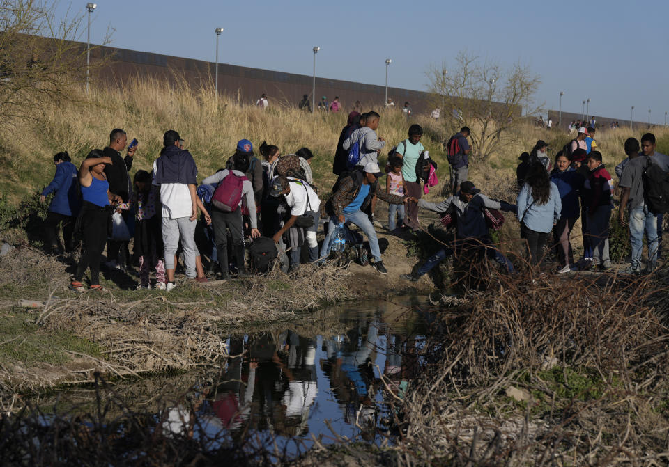 Migrants jump back and forth over the Rio Grande river into the United States and some back into Mexico, in Ciudad Juarez, Wednesday, March 29, 2023, a day after dozens of migrants died in a fire at a migrant detention center in Ciudad Juarez. (AP Photo/Fernando Llano)