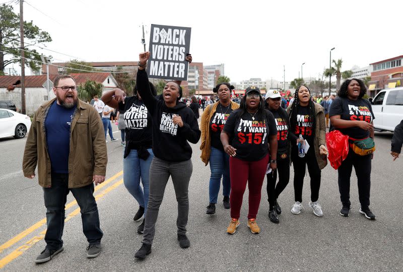 Protestors shout slogans against support of Democratic U.S. presidential candidate and former South Bend Mayor Pete Buttigieg while he leaves from a march for striking McDonald's workers in Charleston