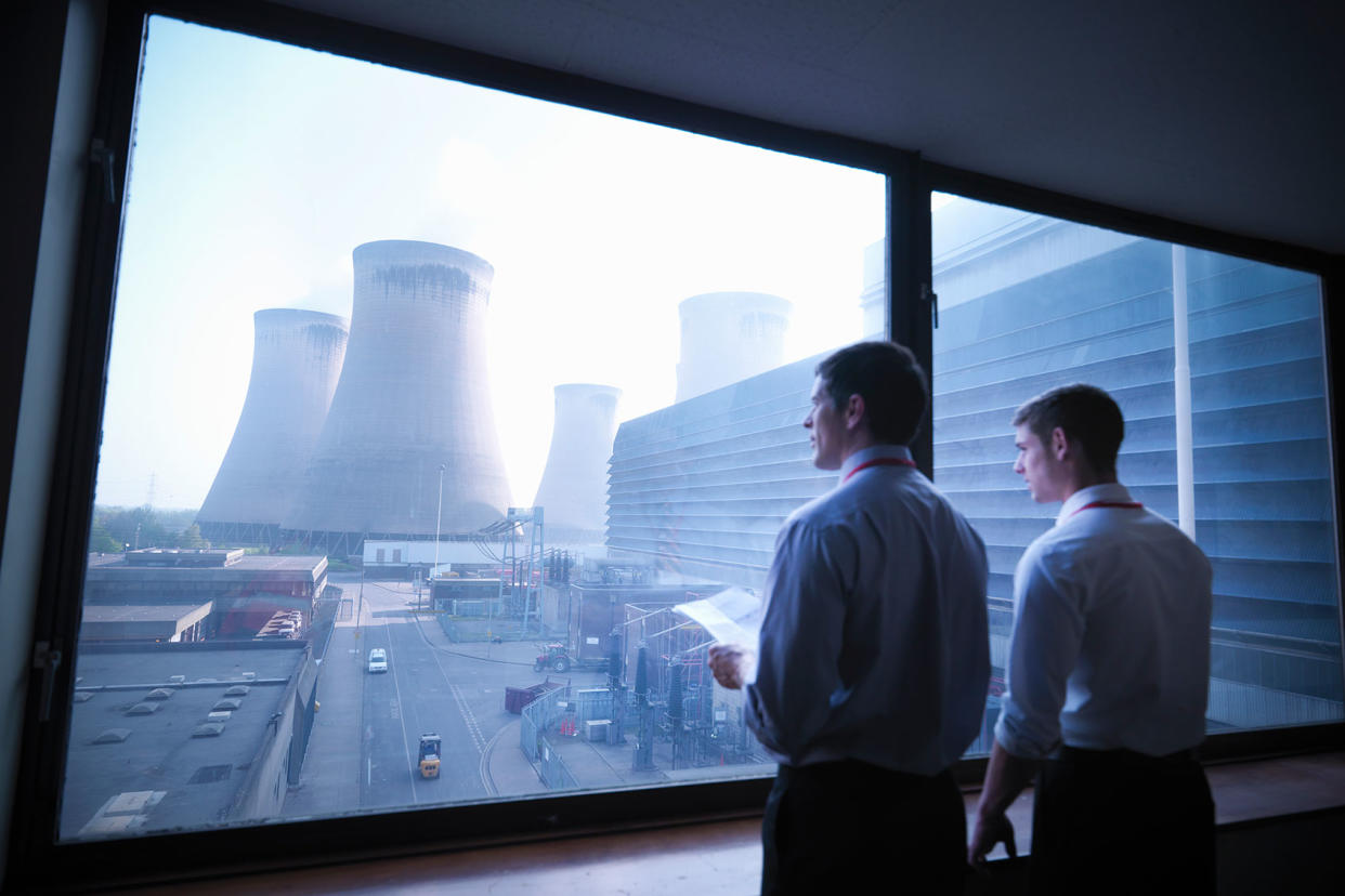 Workers looking over at nuclear power plant cooling towers Getty Images/Monty Rakusen