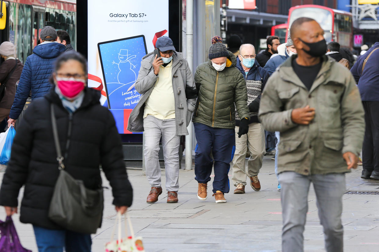  People wearing a face mask walk on the street. Prime Minister Boris Johnson announced on Saturday 19 December, that London and South East of England will move into Tier four restrictions and asked people to 'stay at home'. (Photo by Dinendra Haria / SOPA Images/Sipa USA) 