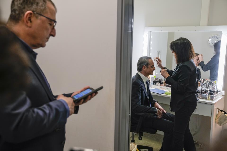 A makeup artist attends to Greece's Prime Minister and New Democracy leader Kyriakos Mitsotakis after an interview at Alpha television station during his election campaign in northern Athens, Greece, Tuesday, April 25, 2023. (AP Photo/Thanassis Stavrakis)