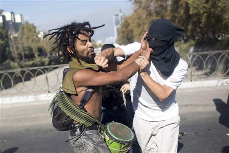 Demonstrators fight each other during the first rally against the government of Michelle Bachelet in Santiago, March 22, 2014. REUTERS/Pablo Sanhueza