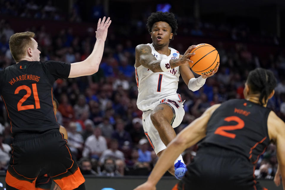 FILE - Auburn guard Wendell Green Jr. drives to the basket between Miami forward Sam Waardenburg, left, and guard Isaiah Wong during the second half of a college basketball game in the second round of the NCAA men's tournament March 20, 2022, in Greenville, S.C. Auburn's backcourt is mostly returning intact with Green, K.D. Johnson and Zep Jasper. (AP Photo/Chris Carlson, File)