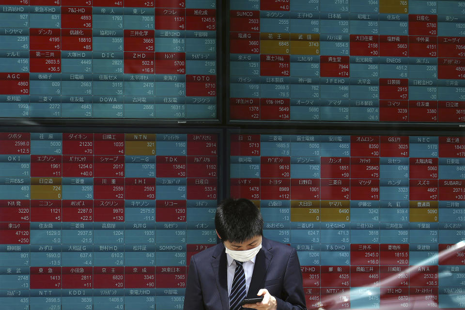 A man wearing a protective mask stands in front of an electronic stock board showing Japan's Nikkei 225 index at a securities firm Wednesday, May 26, 2021, in Tokyo. Asian stock markets rose Wednesday as inflation fears eased and investors looked ahead to U.S. data that are expected to show economic growth accelerating. (AP Photo/Eugene Hoshiko)