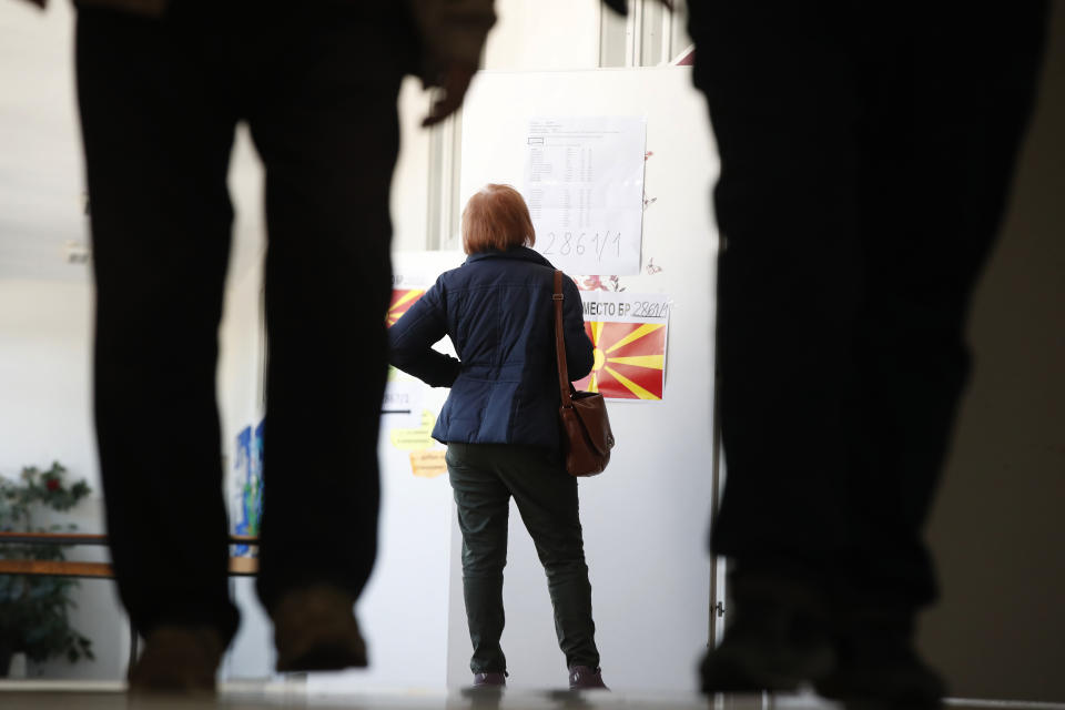 A woman looks for her polling place at a polling station to vote for the presidential election, in Skopje, North Macedonia, on Wednesday, April 24, 2024. Around 1.8 million registered voters can cast ballots on Wednesday for one of the seven candidates who are competing for the largely ceremonial president's post in the first round of elections in North Macedonia. (AP Photo/Boris Grdanoski)