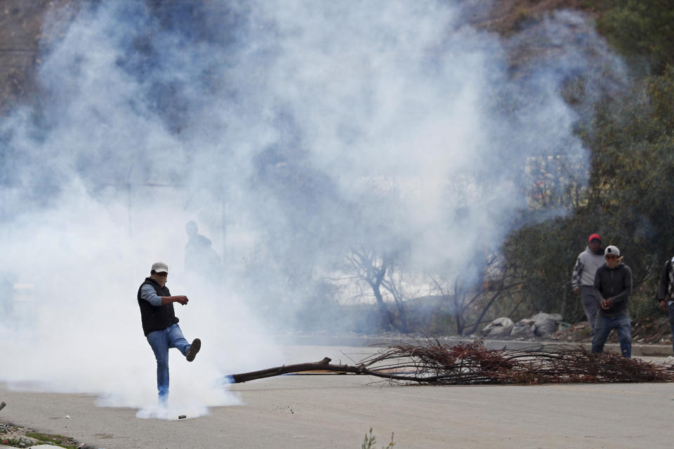 A man kicks a tear gas canister during clashes between police and supporters of former President Evo Morales who set up barricades in La Paz, Bolivia, Monday, Nov. 11, 2019. Morales' Nov. 10 resignation, under mounting pressure from the military and the public after his re-election victory triggered weeks of fraud allegations and deadly demonstrations, leaves a power vacuum and a country torn by protests against and for his government. (AP Photo/Juan Karita)