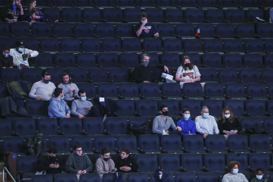 Fans watch the New York Knicks play against the Golden State Warriors in an NBA basketball game Tuesday, Feb. 23, 2021, in New York. For the first time this season, fans were allowed to attend a Knicks home game. (Wendell Cruz/Pool Photo via AP)