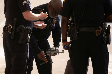 Police officers grab a drone which crashed near activists taking part in protest rally against the National Rifle Association (NRA) in Dallas, Texas, U.S., May 4, 2018. REUTERS/Adrees Latif