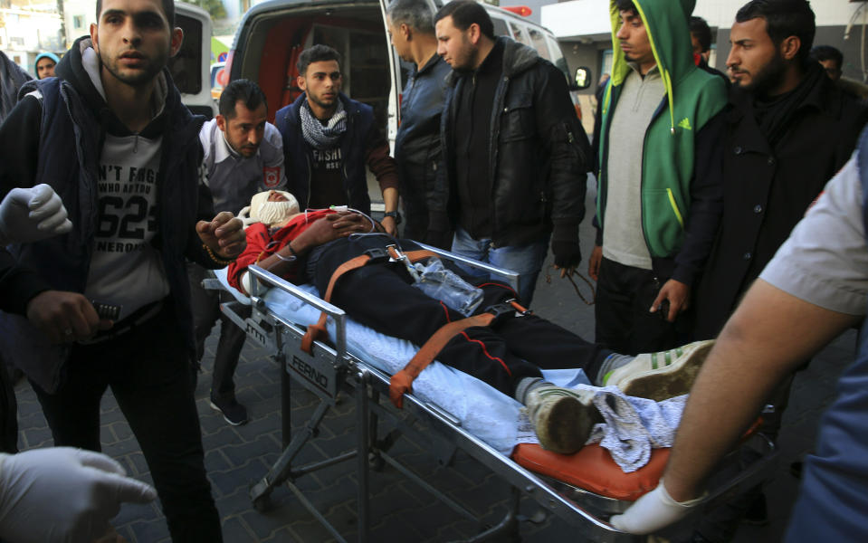 FILE - Palestinian medics and protestors move a serious wounded youth, who was shot in the head by Israeli troops during a protest at the Gaza Strip's border with Israel, into the treatment room of Shifa hospital in Gaza City, Friday, Feb. 8, 2019. Rights groups said Thursday. Dec. 2, 2021, that Israel failed to investigate shootings that killed more than 200 Palestinians and wounded thousands at violent protests along the Gaza frontier in recent years, strengthening the case for the International Criminal Court to intervene. (AP Photo/Adel Hana, File)