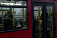 People wear face masks to curb the spread of coronavirus, which is still a mandatory requirement on Transport for London public transport services, as they travel on a bus going over London Bridge towards the City of London financial district during the morning rush hour in London, Monday, Jan. 24, 2022. The British government have asked people to return to working in offices starting Monday as they ease coronavirus restrictions. (AP Photo/Matt Dunham)