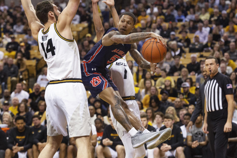 Auburn's J'Von McCormick, right, passes around Missouri's Reed Nikko, left, during the first half of an NCAA college basketball game Saturday, Feb. 15, 2020, in Columbia, Mo. (AP Photo/L.G. Patterson)