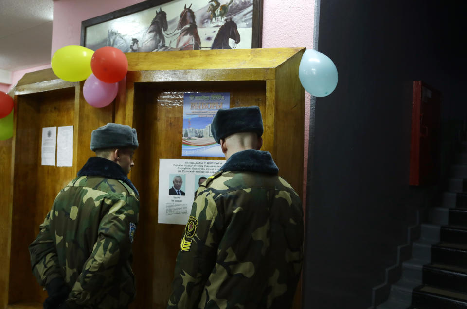 Belarus' Army servicemen examine a candidates list at a polling station during parliamentary elections, in Minsk, Belarus, Sunday, Nov. 17, 2019. (AP Photo/Sergei Grits)