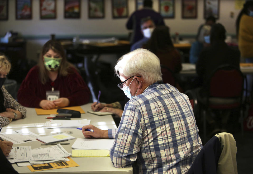 Election officials begin the process of recounting one of two unresolved races that will settle whether Virginia Republicans have reclaimed the majority in the House of Delegates, Thursday, Dec. 2, 2021 in Virginia Beach, Va. (Stephen M. Katz/The Virginian-Pilot via AP)