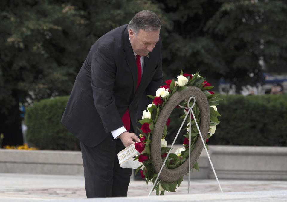 U.S. Secretary of State Mike Pompeo adjusts the sash on a wreath during a ceremony at the National War Memorial in Ottawa, Thursday Aug. 22, 2019. (Adrian Wyld/The Canadian Press via AP)