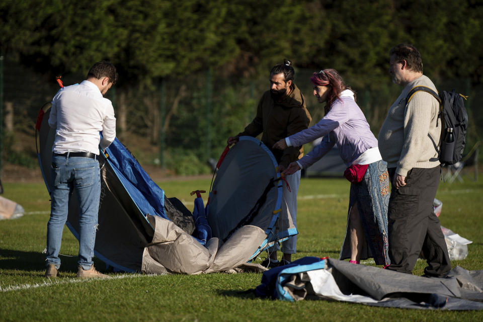 People fold up their tent after camping overnight in the queue before the start of day one of the Wimbledon tennis championships in London, Monday, June 27, 2022. (Aaron Chown/PA via AP)