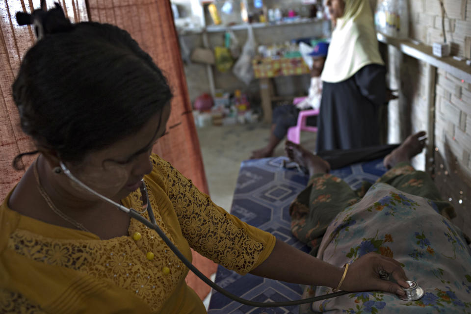 SITTWE, BURMA - MAY 06: A medic checks up on a pregnant woman in a makeshift clinic and pharmecy in the Thet Kae Pyin refugee camp on May 6, 2014 in Sittwe, Burma. Some 150,000 Rohingya IDP (internally displaced people) are currently imprisoned in refugee camps outside of Sittwe in Rakhine State in Western Myanmar. Medecins Sans Frontieres (MSF), the primary supplier of medical care within the camps, was banned in March by the Myanmar government. Follow up attacks by Buddhist mobs on the homes of aid workers in Sittwe put an end to NGO operations in the camps. Though some NGOs are beginning to resume work, MSF remains banned, and little to no healthcare is being provided to most Rohingya IDPs. One Rohingya doctor is servicing 150,000 refugees with limited medication. Several Rakhine volunteer doctors sporadically enter the camps for two hours a day. Births are the most complicated procedures successfully carried out in the camps, requests to visit Yangon or Sittwe hospitals for life threatening situations require lengthy applications and are routinely denied. Malnutrition and diarrhea are the most widespread issues, but more serious diseases like tuberculosis are going untreated and could lead to the rise of drug resistant tuberculosis (DR-TB).  (Photo by Andre Malerba/Getty Images)