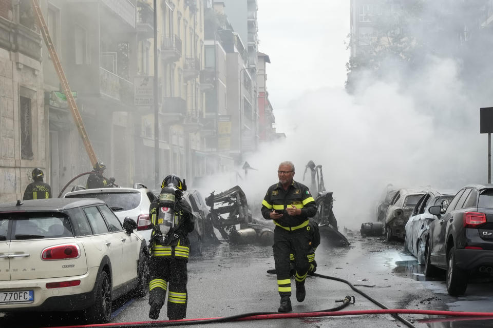 Firefighters work to extinguish a fire in a building after a van exploded in central Milan, northern Italy, Thursday, May 11, 2023. (AP Photo/Luca Bruno)