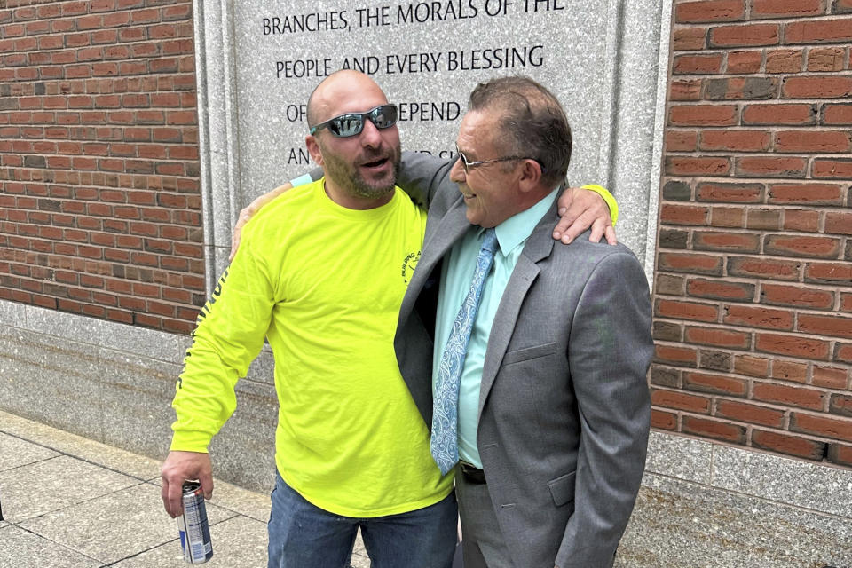 Victor Rosario, right, embraces friend Natale Cosenza, Wednesday, May 3, 2023, outside the federal courthouse in Boston. Rosario, who spent 32 years in prison after he was wrongfully convicted of setting a fire that killed eight people, will receive $13 million from the city of Lowell, Mass., in a settlement of a lawsuit he brought against the city in 2019. (AP Photo/Mark Pratt)