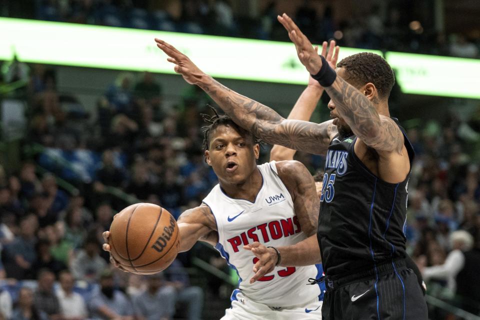 Detroit Pistons guard Marcus Sasser, left, passes the ball around Dallas Mavericks forward P.J. Washington (25) during the first half of an NBA basketball game Friday, April 12, 2024, in Dallas. (AP Photo/Jeffrey McWhorter)