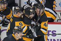 Pittsburgh Penguins' Kris Letang, center, celebrates with Kasperi Kapanen (42) and Evan Rodrigues (9) after his overtime winning goal is announced following a review during an NHL hockey game against the Philadelphia Flyers in Pittsburgh, Thursday, Nov. 4, 2021. (AP Photo/Gene J. Puskar)