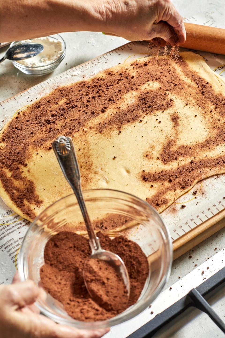 A bowl filled with a chocolate mixture next to a cake.