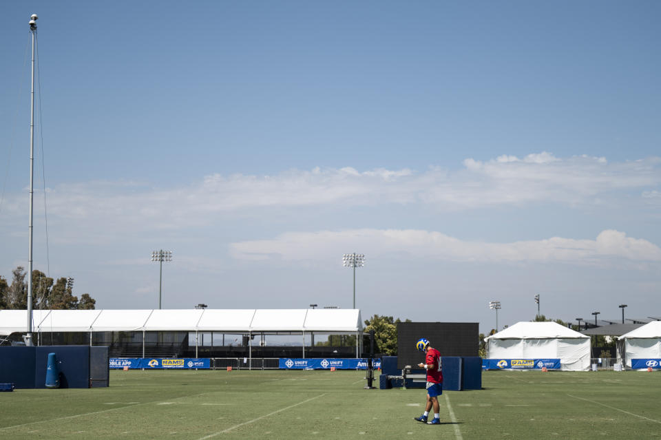 Los Angeles Rams quarterback Luis Perez reads a playbook during NFL football practice Monday, July 25, 2022, in Irvine, Calif. (AP Photo/Kyusung Gong)