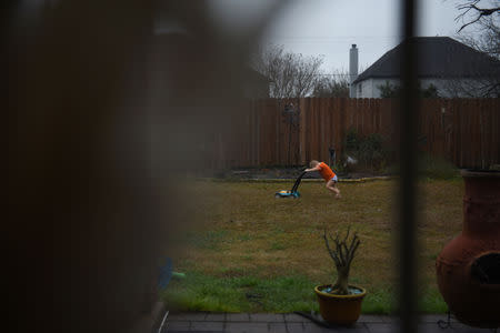 Asa Hoffmann pushes a toy lawnmower in his backyard in San Antonio, Texas, U.S., February 6, 2019. REUTERS/Callaghan O'Hare