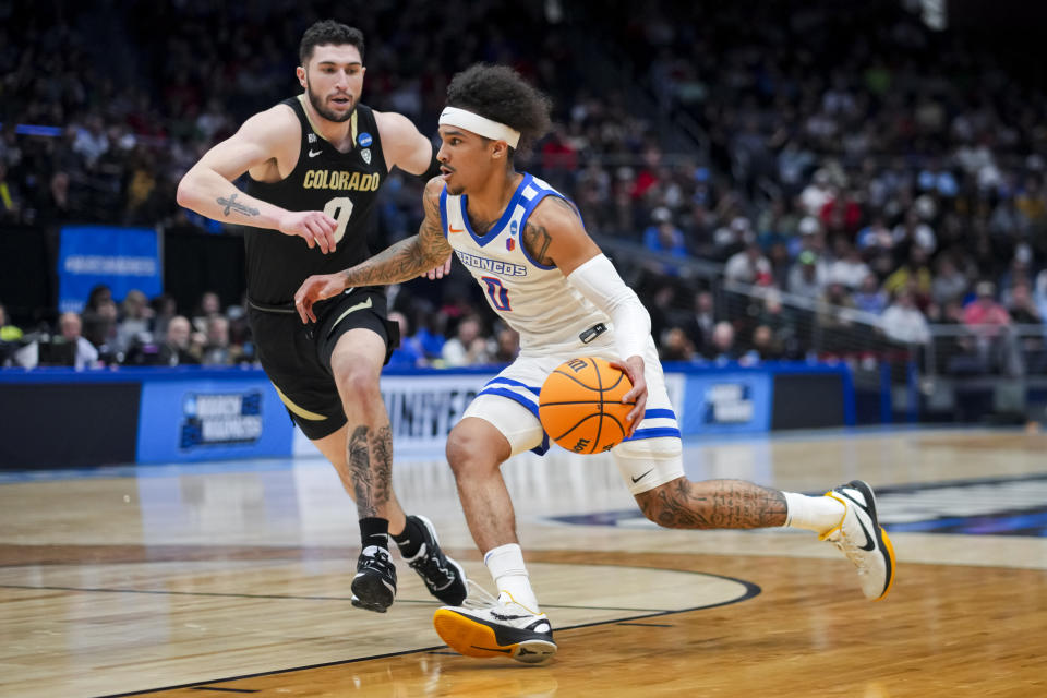 Boise State guard Roddie Anderson III, right, drives to the basket against Colorado guard Luke O'Brien, left, during the first half of a First Four game in the NCAA men's college basketball tournament Wednesday, March 20, 2024, in Dayton, Ohio. (AP Photo/Aaron Doster)