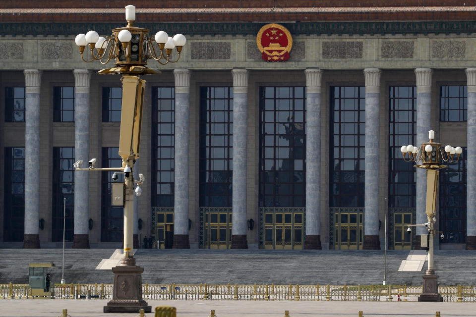 In this Sunday, Feb. 23, 2020, photo, a paramilitary policeman stands guard on a deserted Tiananmen Square against the Great Hall of the People in Beijing. China announced Monday it has postponed its most important political meeting of the year because of the outbreak of the new virus. (AP Photo/Andy Wong)